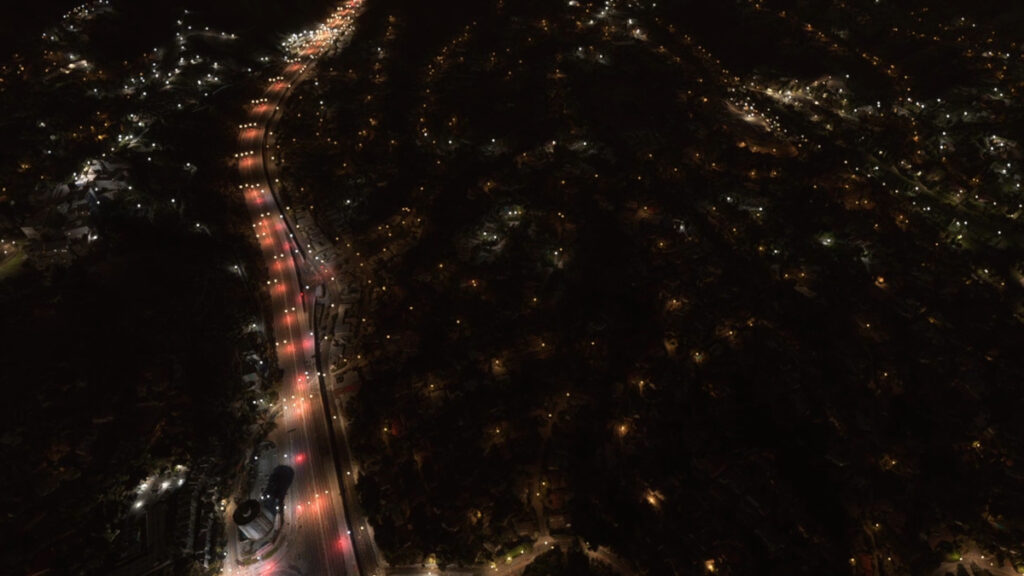 a bird view on a virtual Los Angeles by night over a red-lighted highway